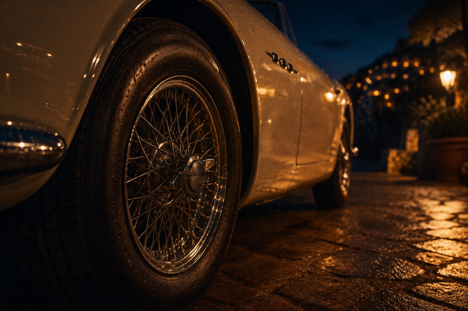 A cream vintage convertible parked on a Mediterranean terrace at deep amber sunset, palm silhouette against a burning sky